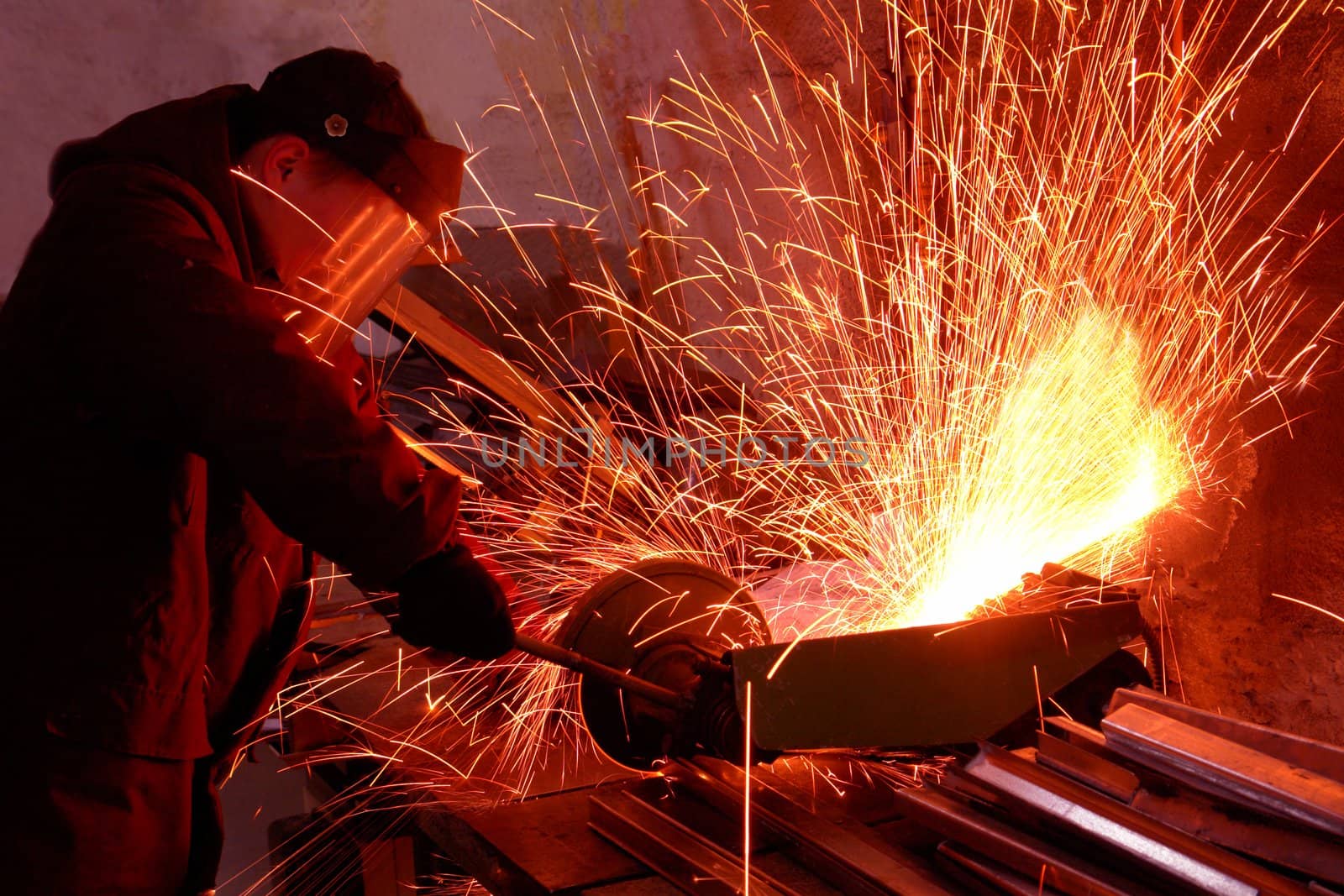 worker white hot sparks at grinding steel material