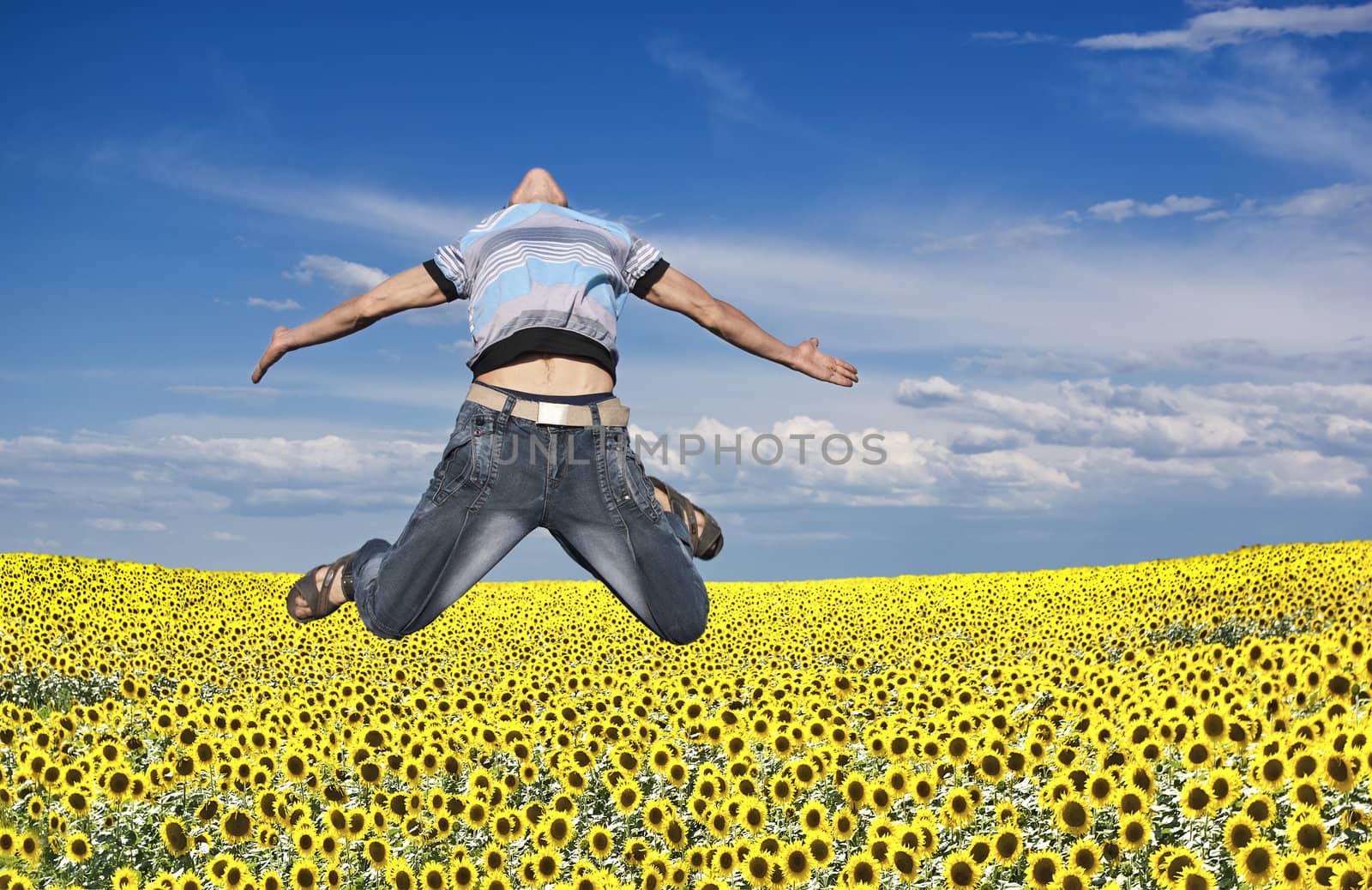 Boy jumping against a background of field and sky