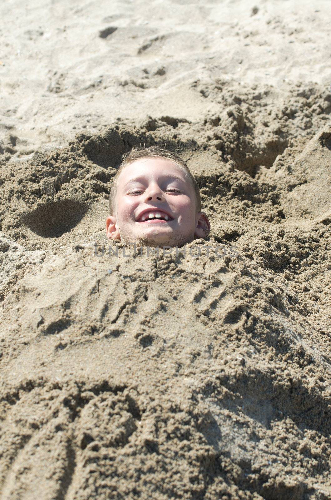 Child covered with beach sand