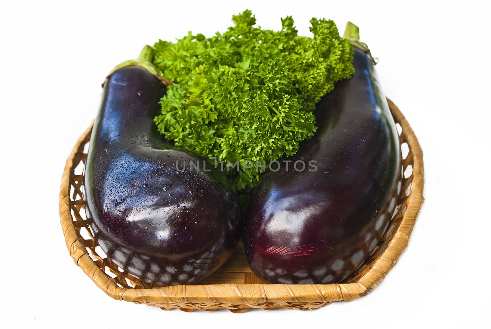 Two aubergine in wood bowl isolated over white