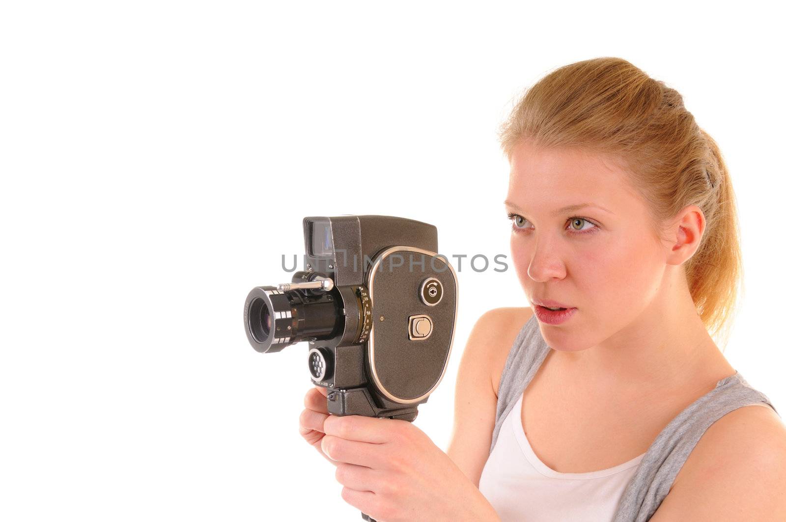 Beauty girl is shooting a film by old video camera. On white background.