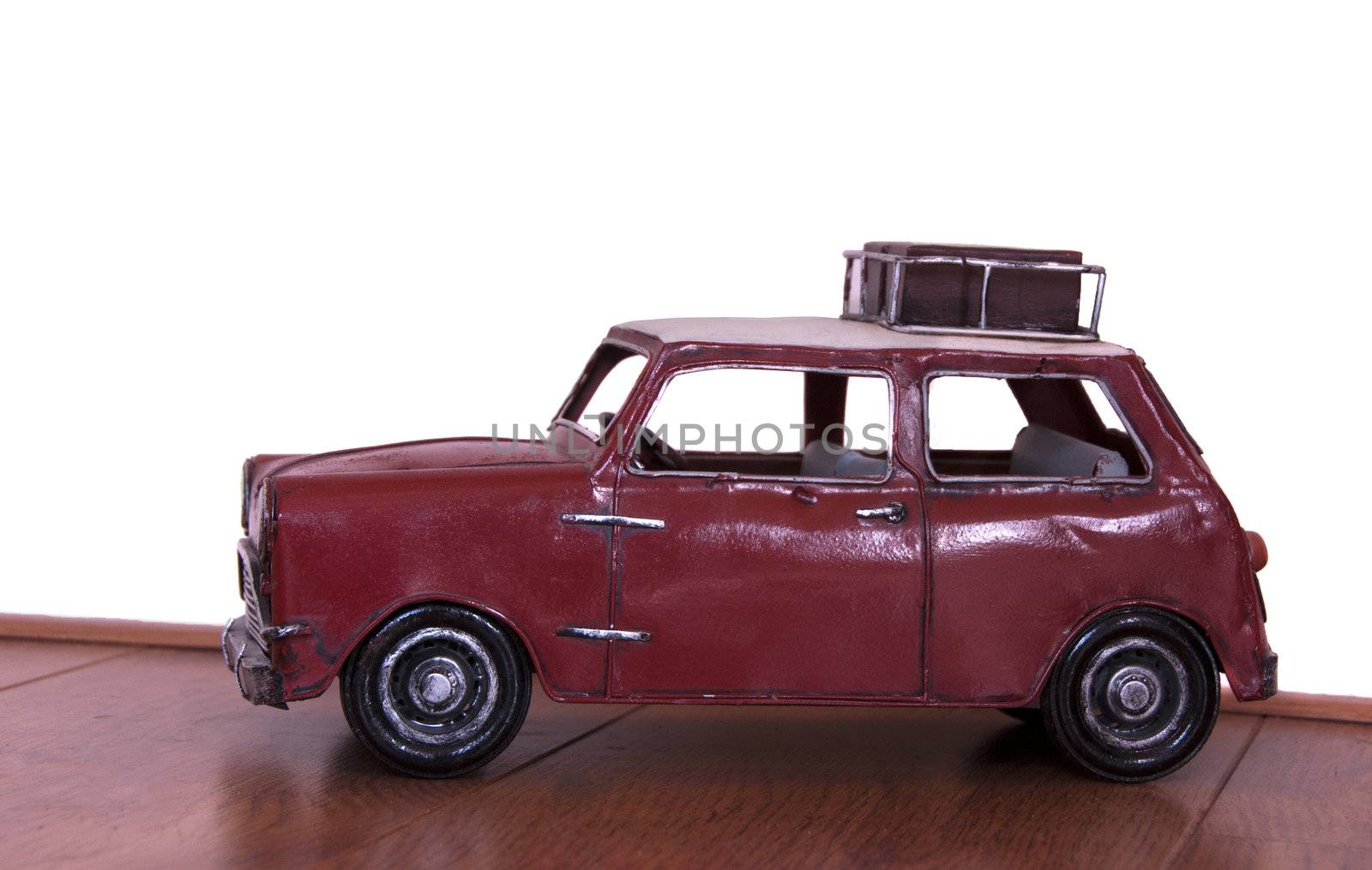 old metal car model with suitcase on the roof by compuinfoto