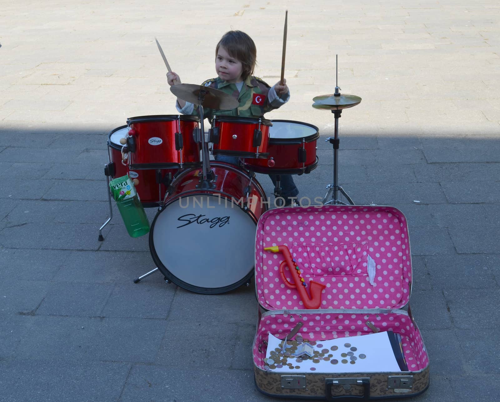 VILNIUS, LITHUANIA MAY 2012 Young kid child play with drums. Earn money in street music day.