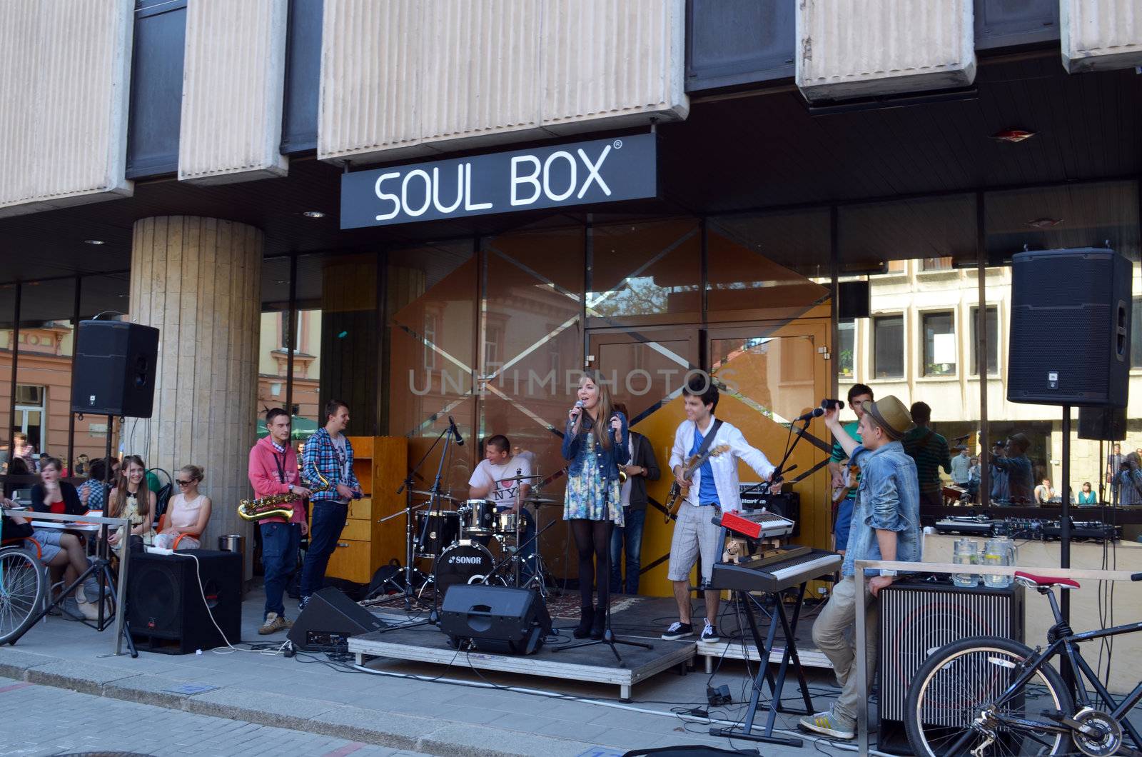 VILNIUS, LITHUANIA MAY 2012. Young vocalist woman and stundents play guitar drums and other instruments and sing in street music day.