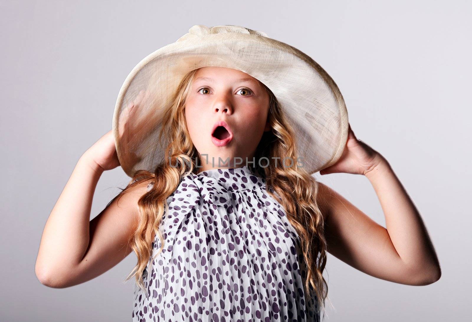 Surprised girl in summer hat over white background