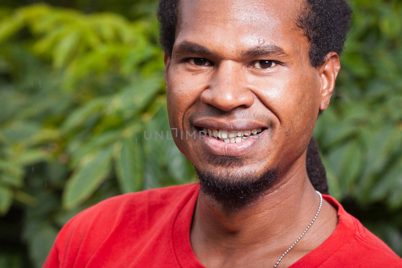 Close-up portrait of a dark skinned smiling young man