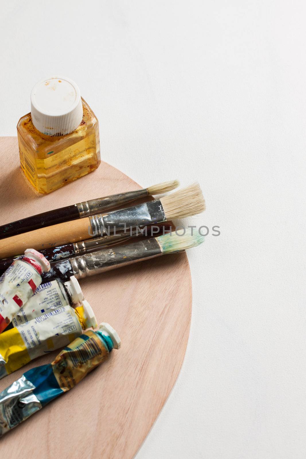 Paintbrushes and paints on a canvas by Jaykayl