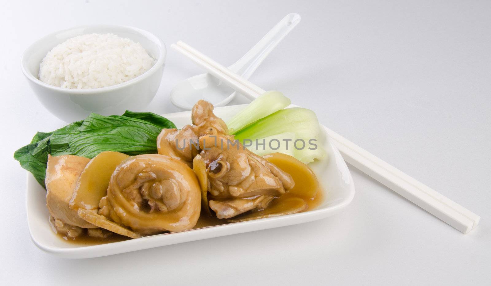 Chicken with rice and vegetables in background