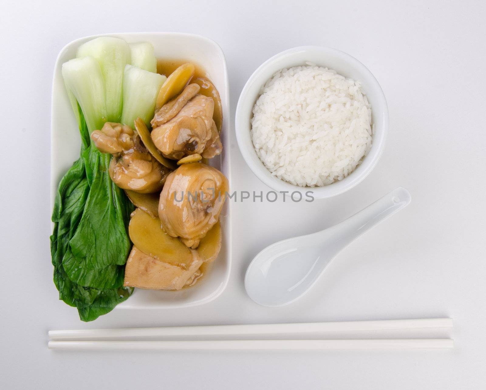 Chicken with rice and vegetables in background