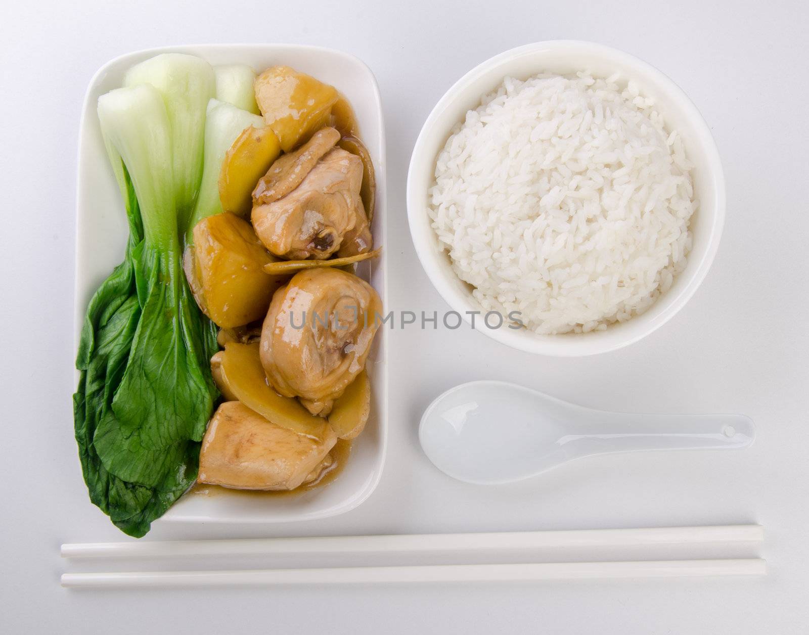 Chicken with rice and vegetables in background