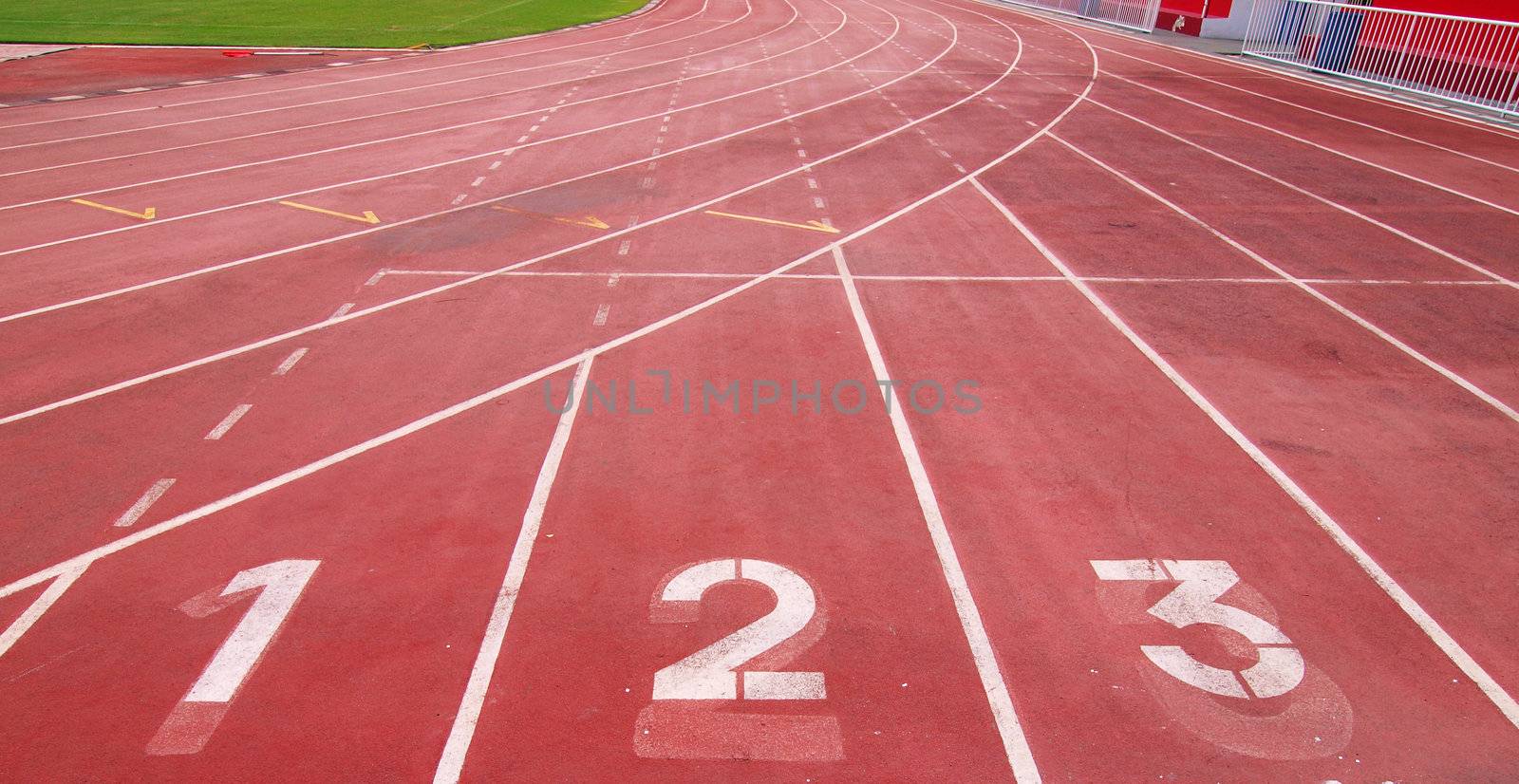 Lanes of a red race track with numbers and red seats in the stadium