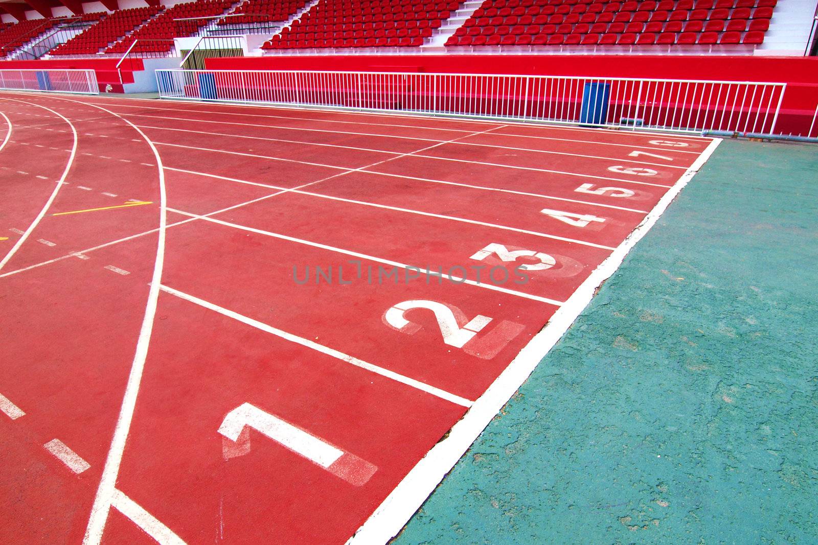 Lanes of a red race track with numbers and red seats in the stadium