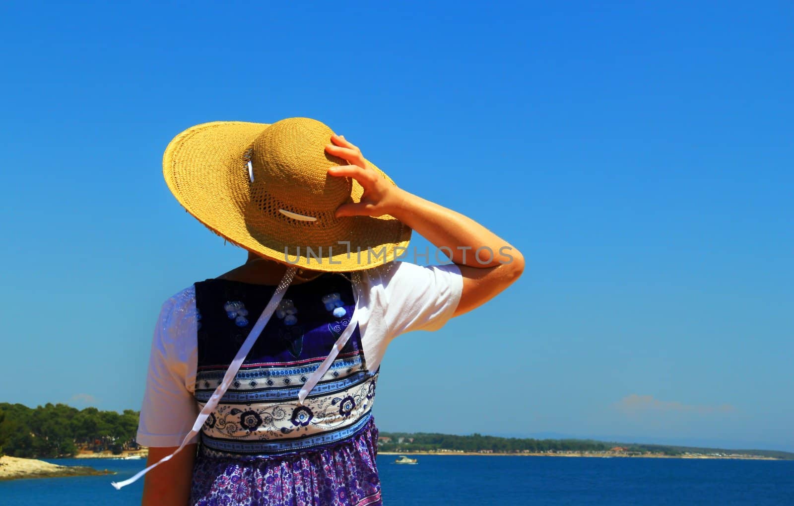 Woman is observing small port and sea.