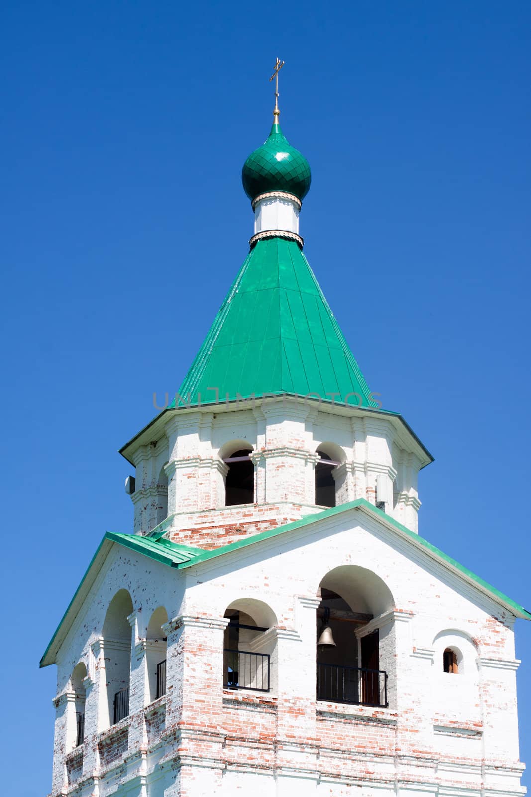 An old orthodox white church wiyh green roof

