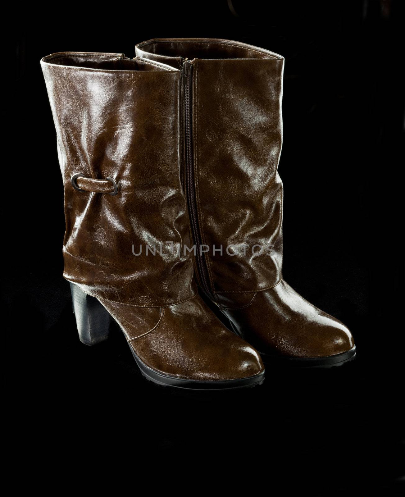 high brown female boots on the black background