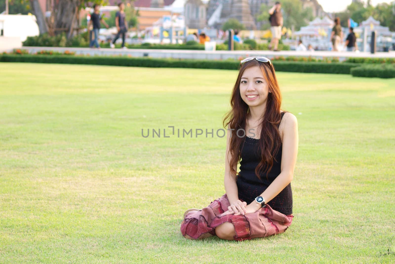 a portrait of attractive asian woman sitting on green grass fiel by jakgree