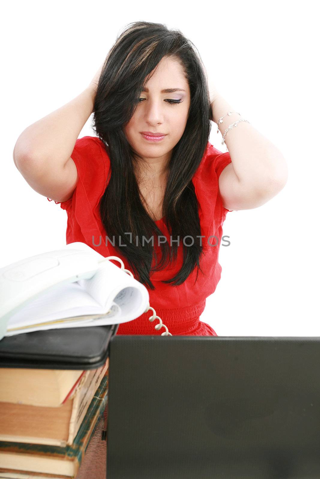 Young tired business woman with headache sitting at computer in workplace holding head