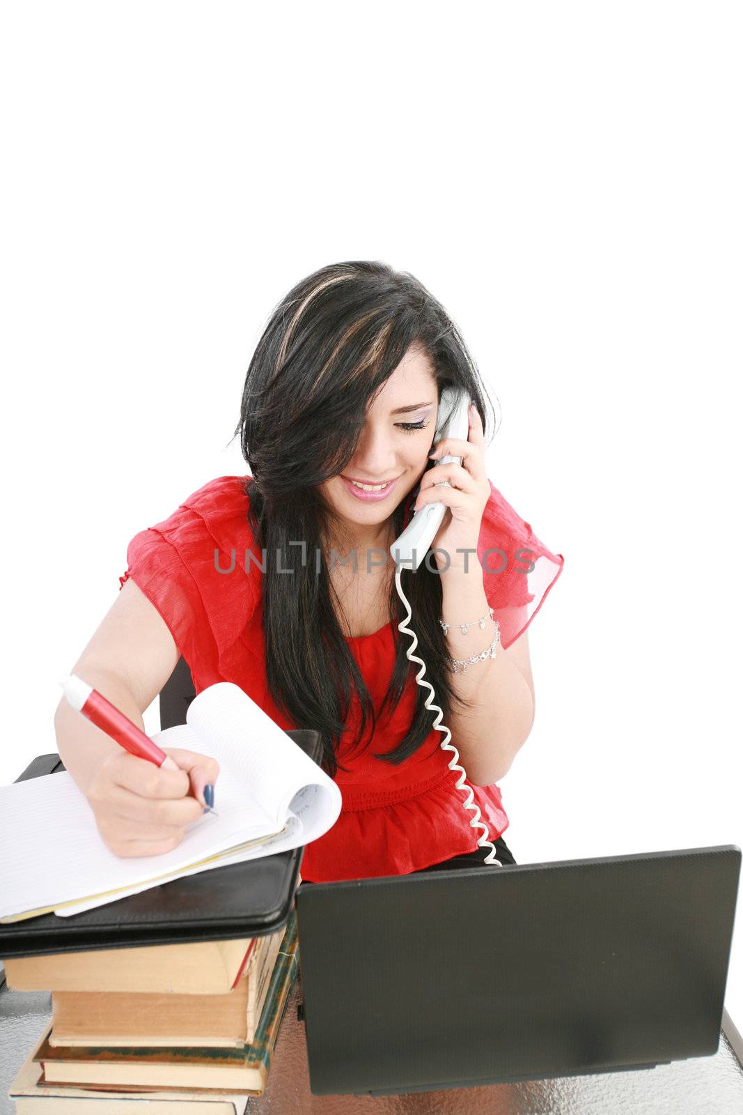 Smiling young business woman on phone taking notes in office by dacasdo