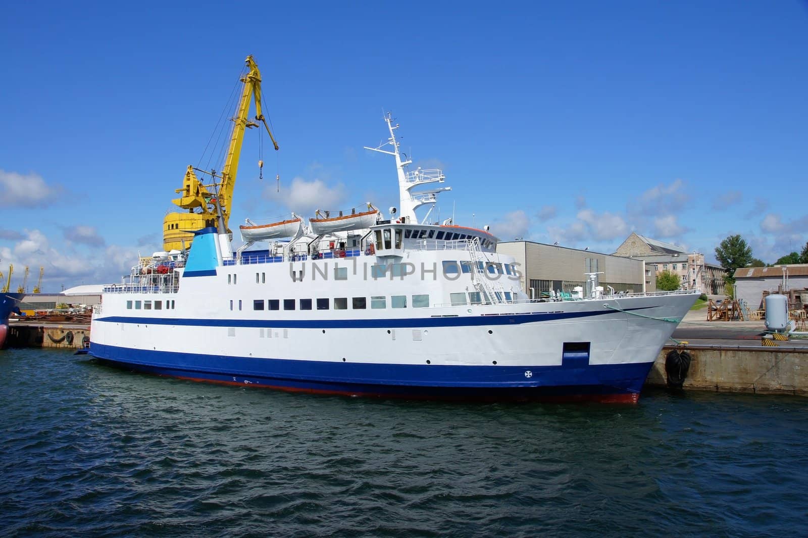 Small white passenger ferry costs in port