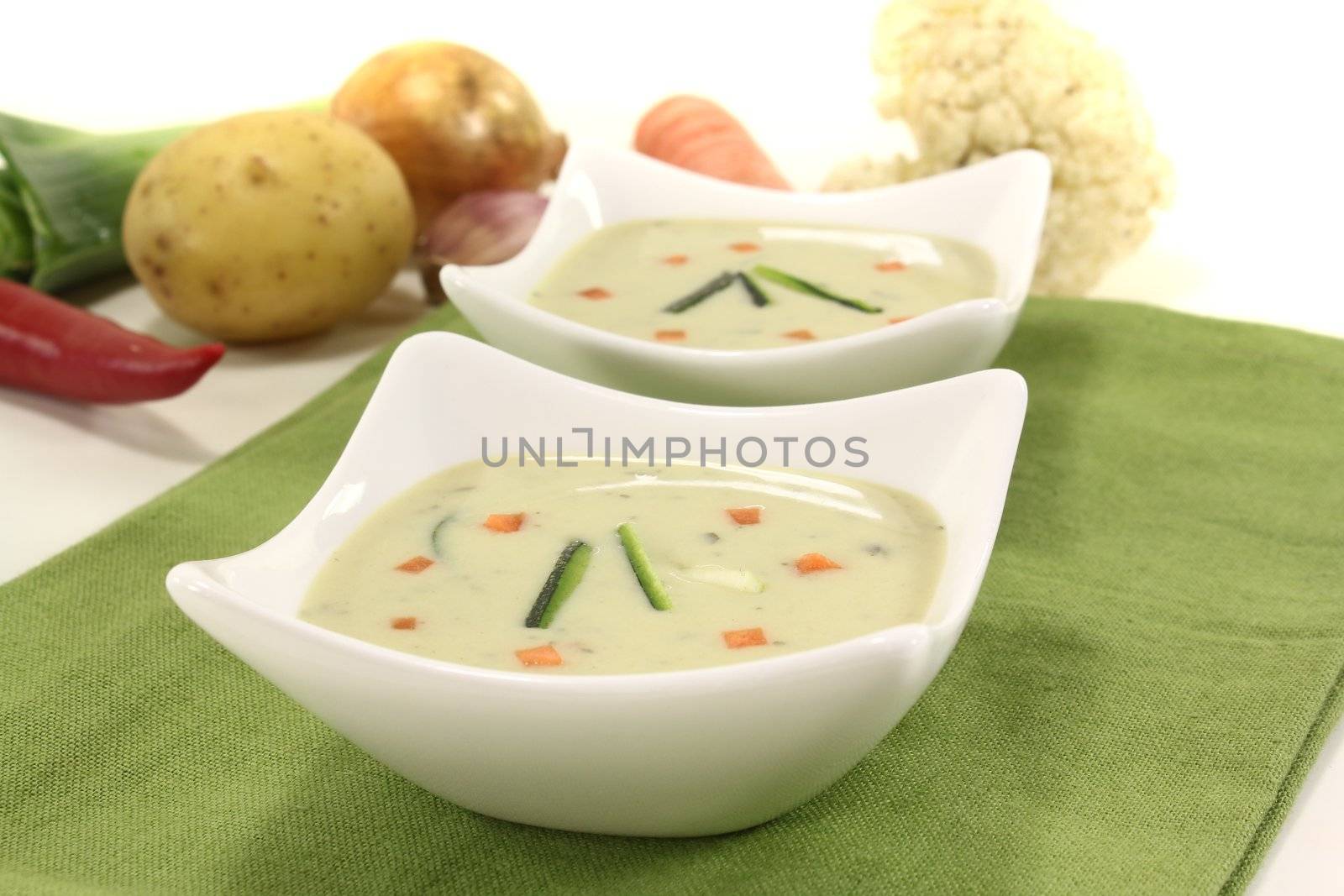 fresh vegetable creme soup with zucchini and carrots on a light background