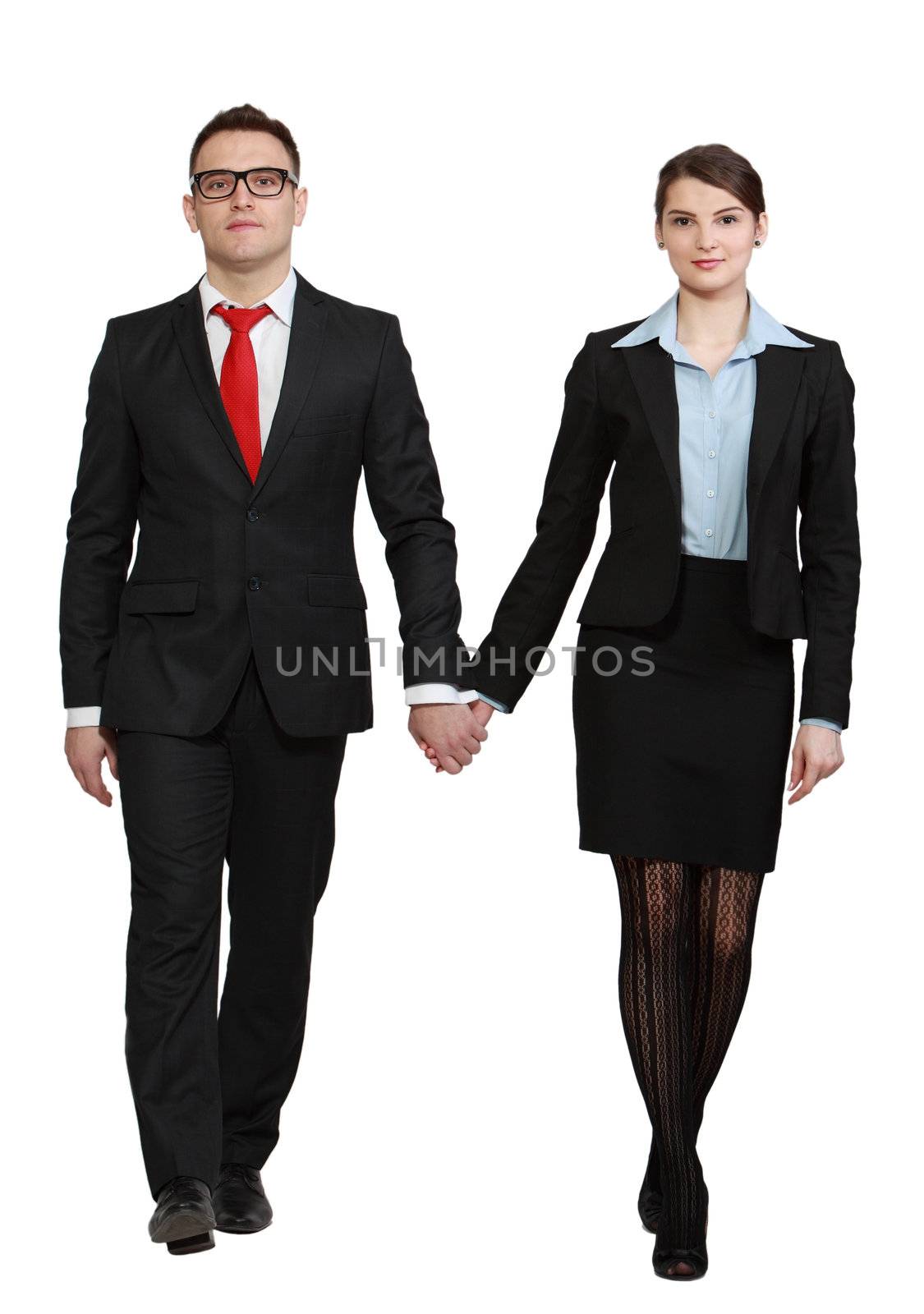 Young couple walking to the camera against a white background.