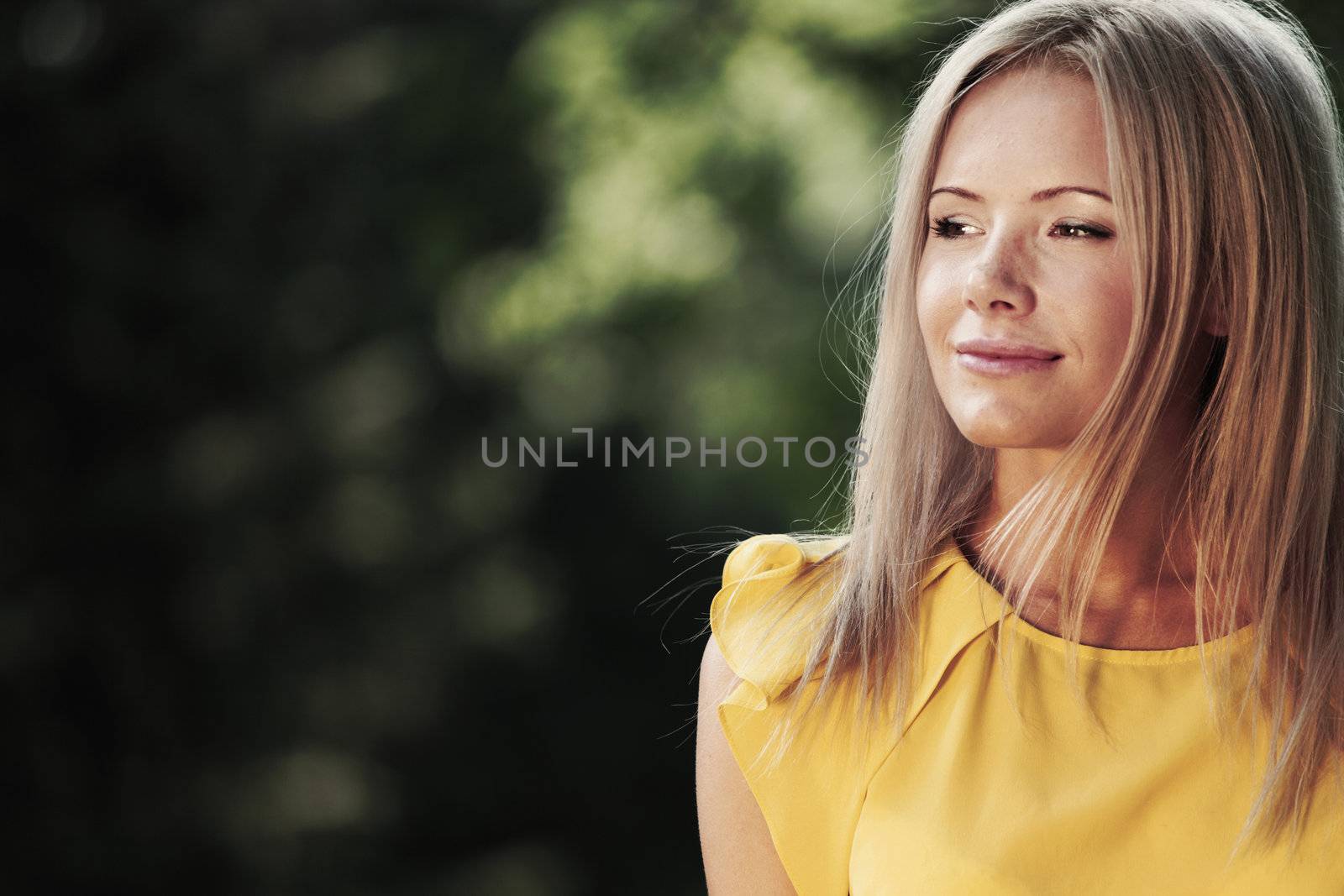 happy woman posing against a background of trees