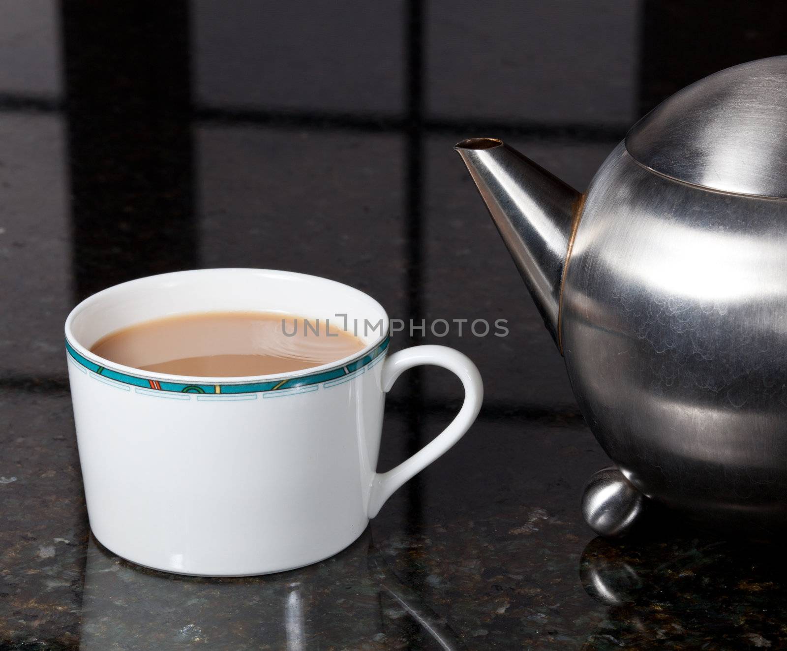 Fresh tea poured into white cup on marble kitchen worktop