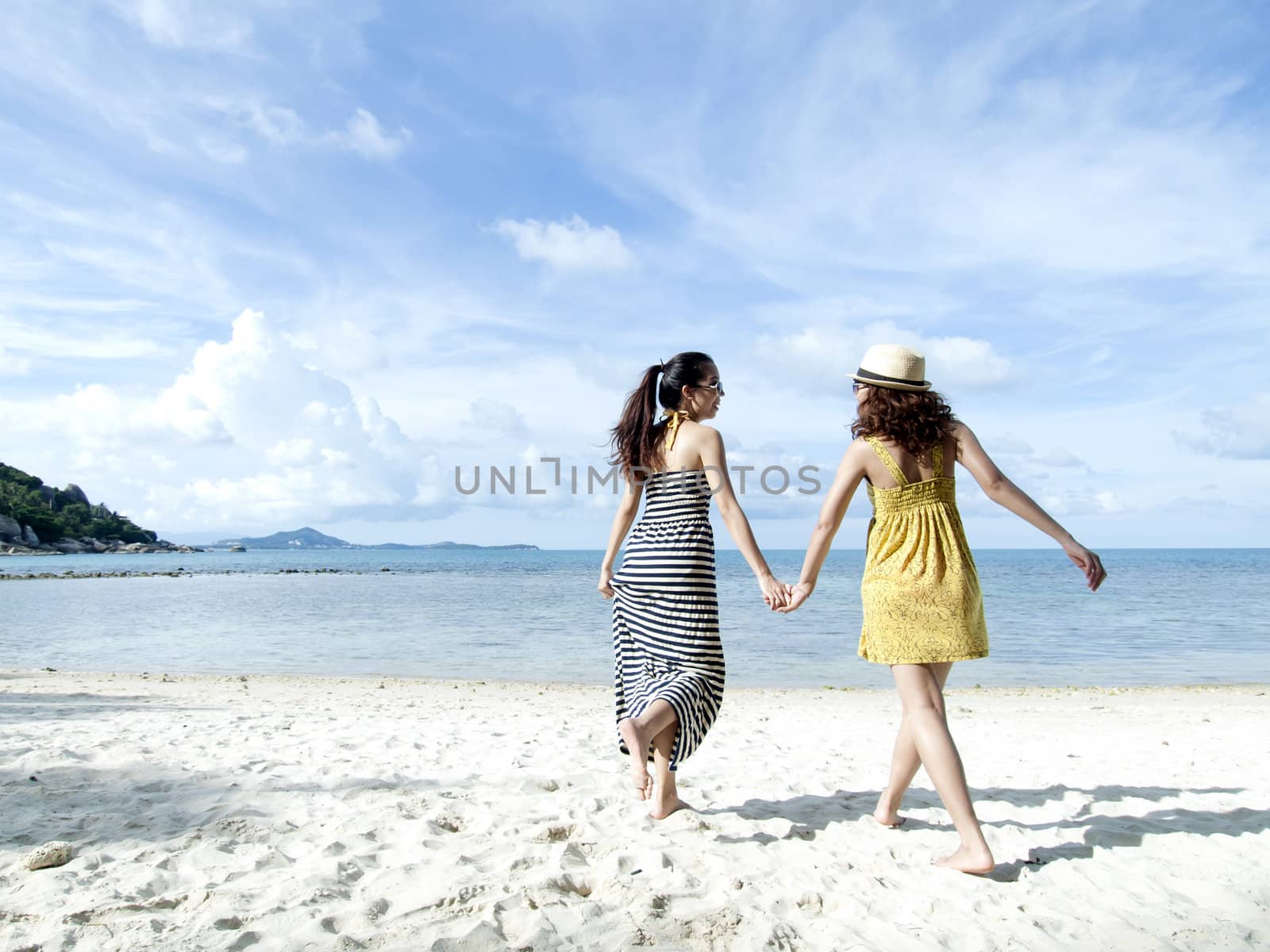 woman happy together on sand beach with blue sky background by jakgree