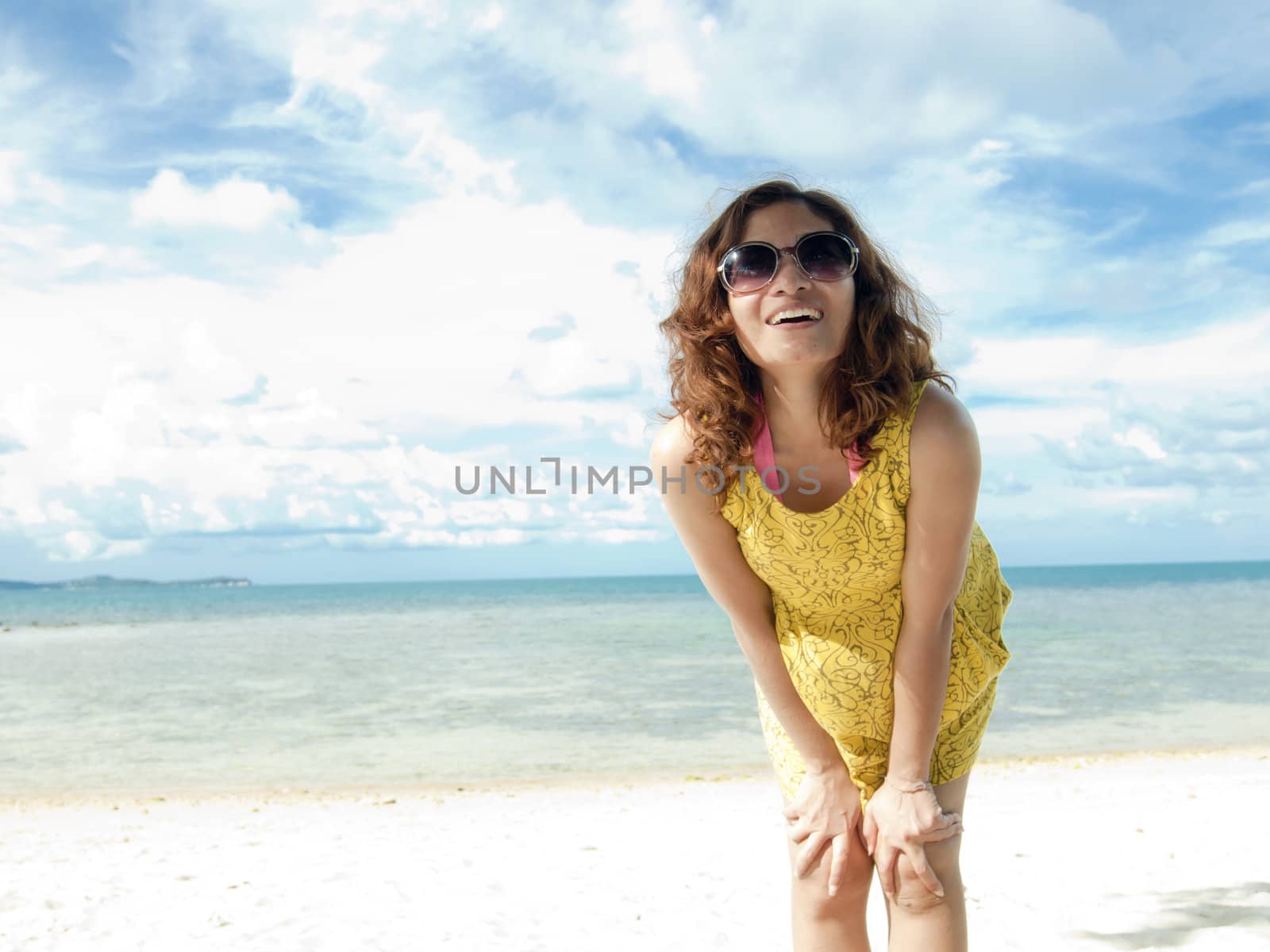 Asian Women happy on the Beach with vibrant yellow dress