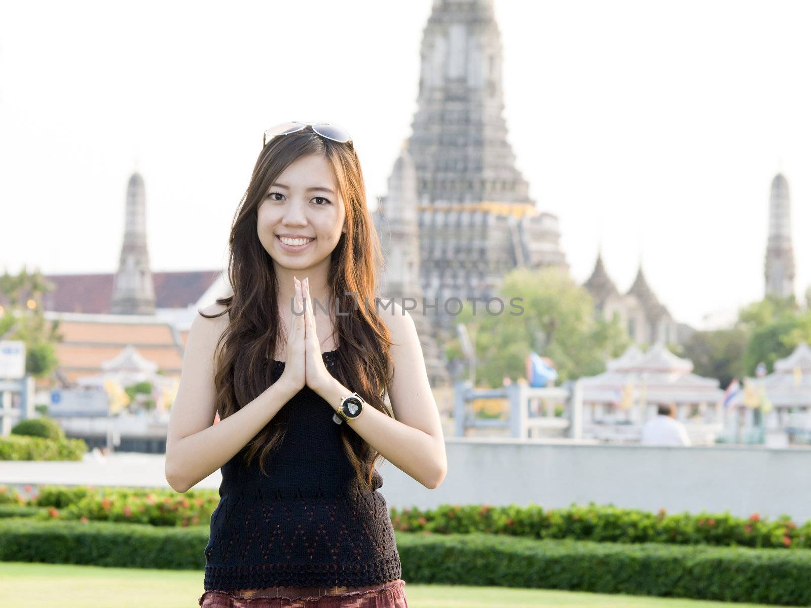 Attractive asian woman greeting with Temple of Dawn Wat Arun bac by jakgree
