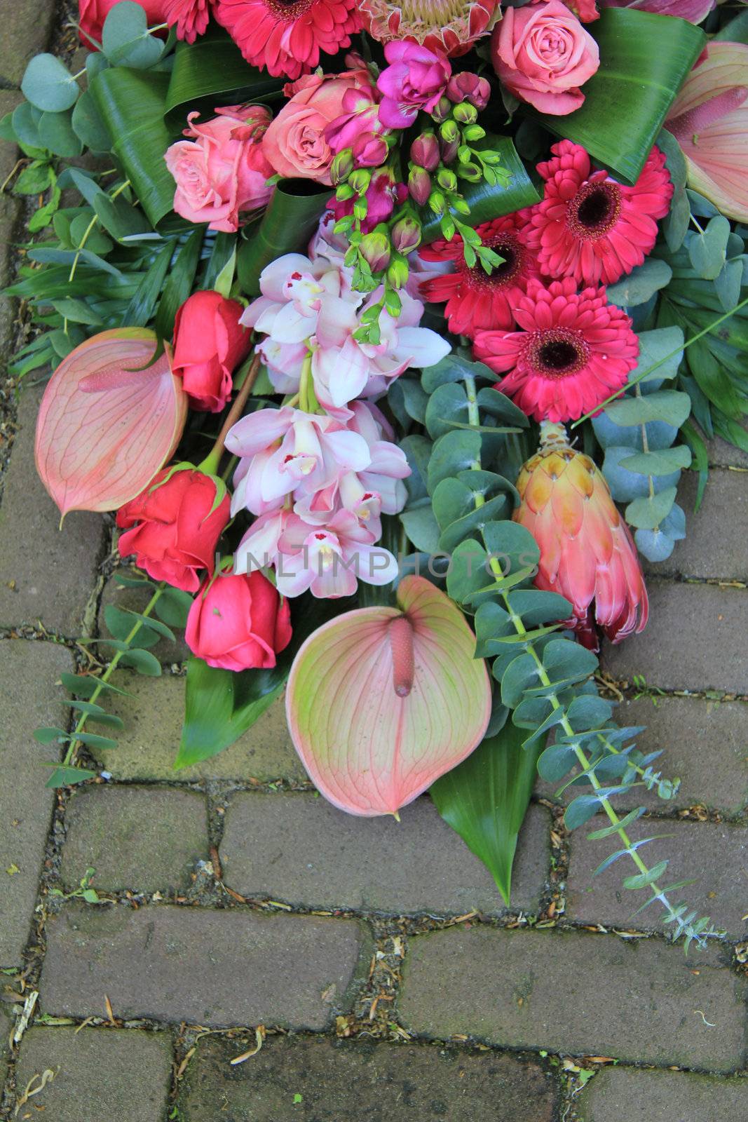 Big sympathy bouquet in different shades of pink on the pavement
