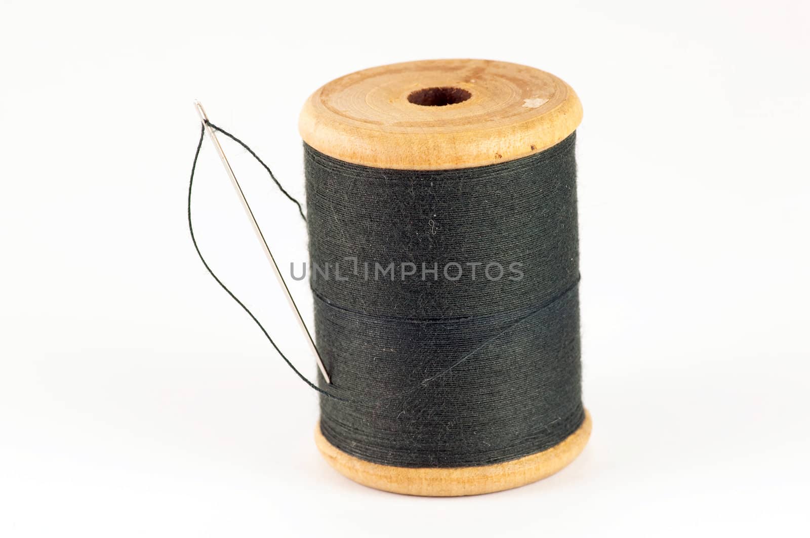 Spool of thread with needle  on white background