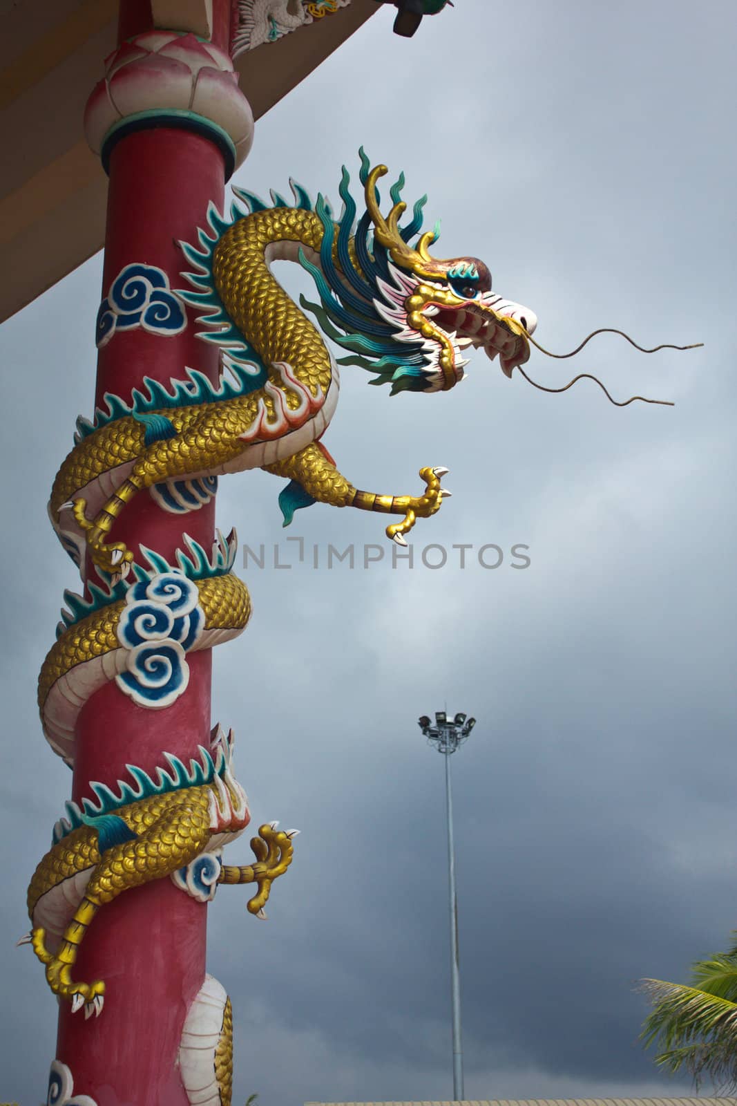 Stock Photo -Golden Chinese Dragon Wrapped around red pole and bright sky