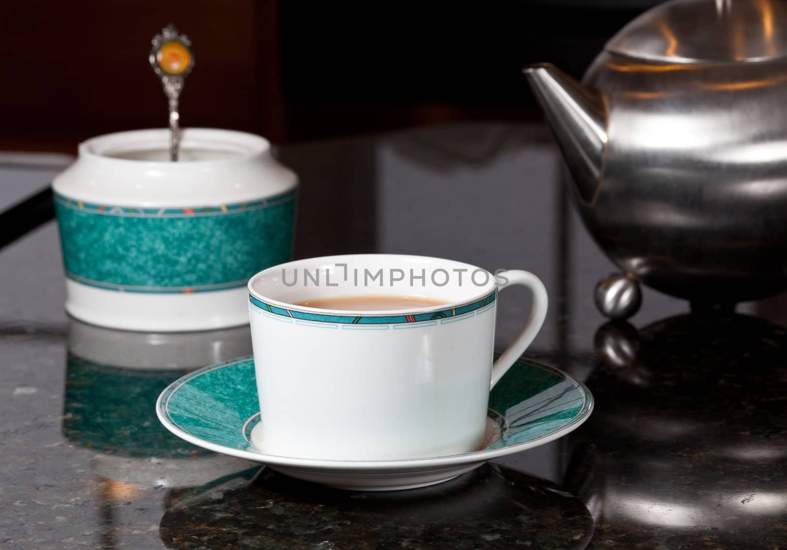 Fresh tea poured into white cup on marble kitchen worktop