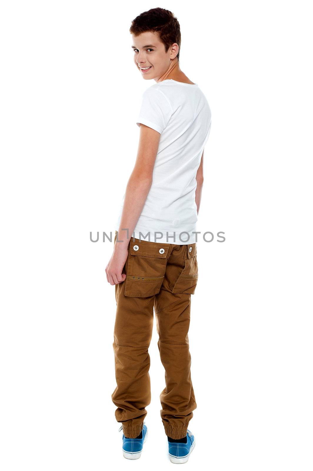 Trendy young boy turning back and smiling at camera