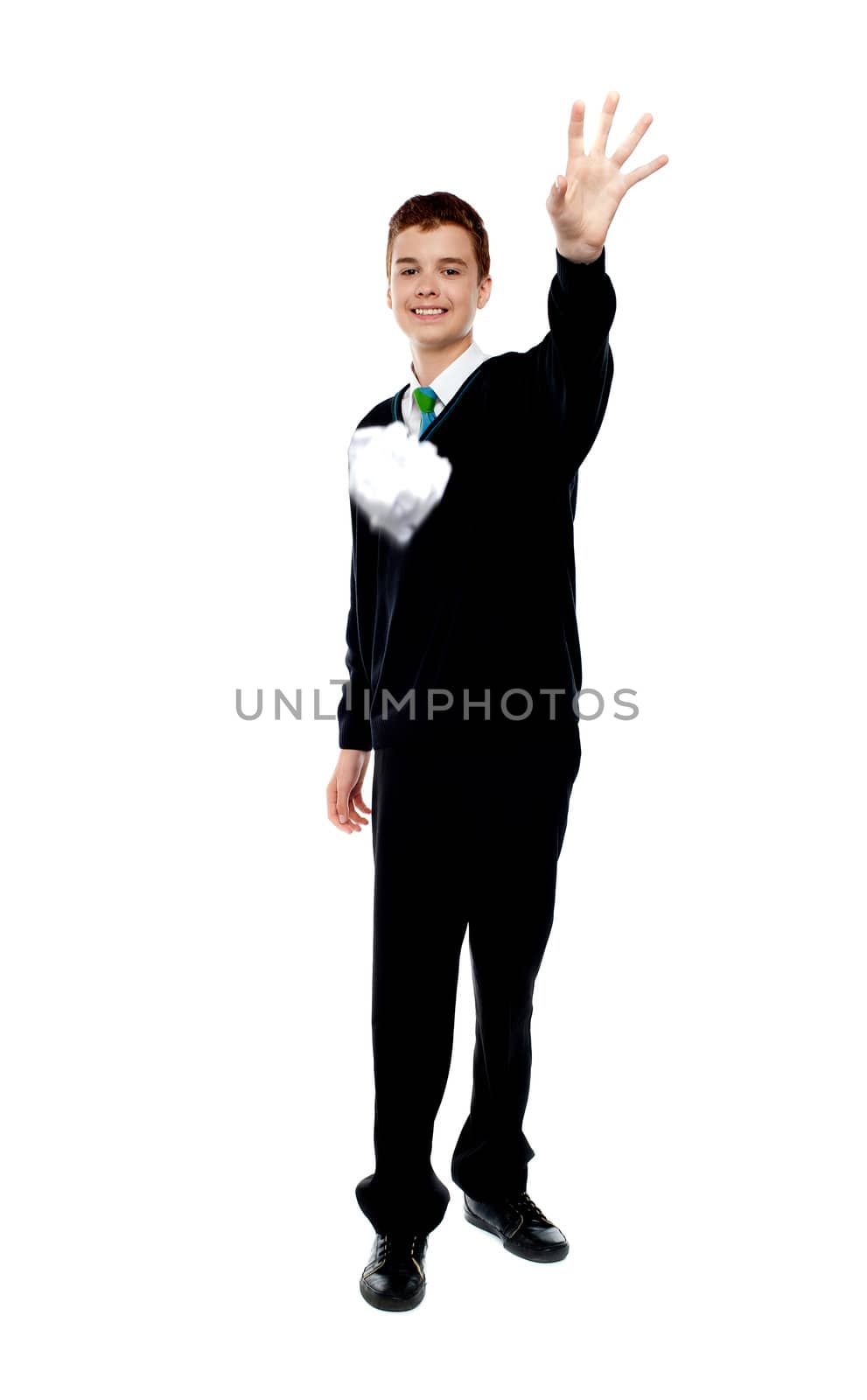 Cheerful young boy throwing paper isolated over white
