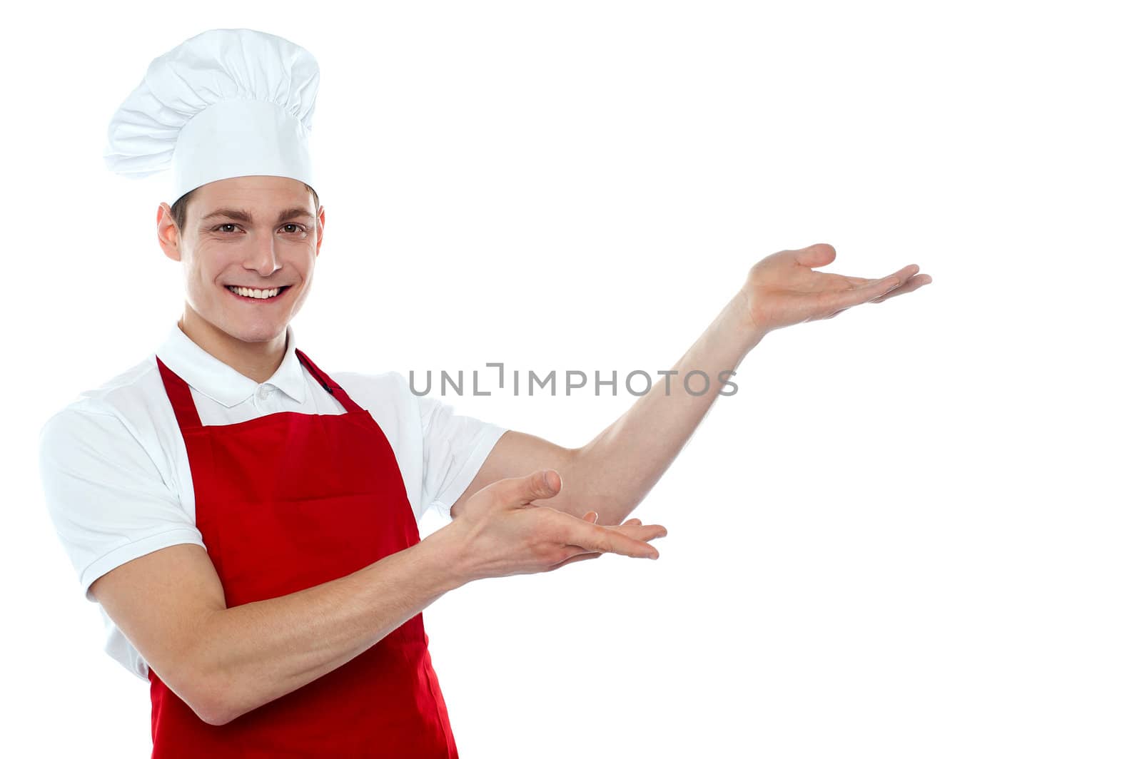 Male chef in red uniform presenting copy space isolated over white