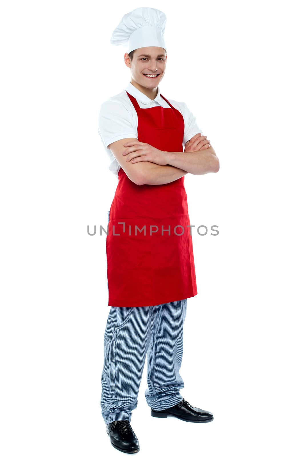 Full length shot of handsome smiling male chef posing with crossed arms