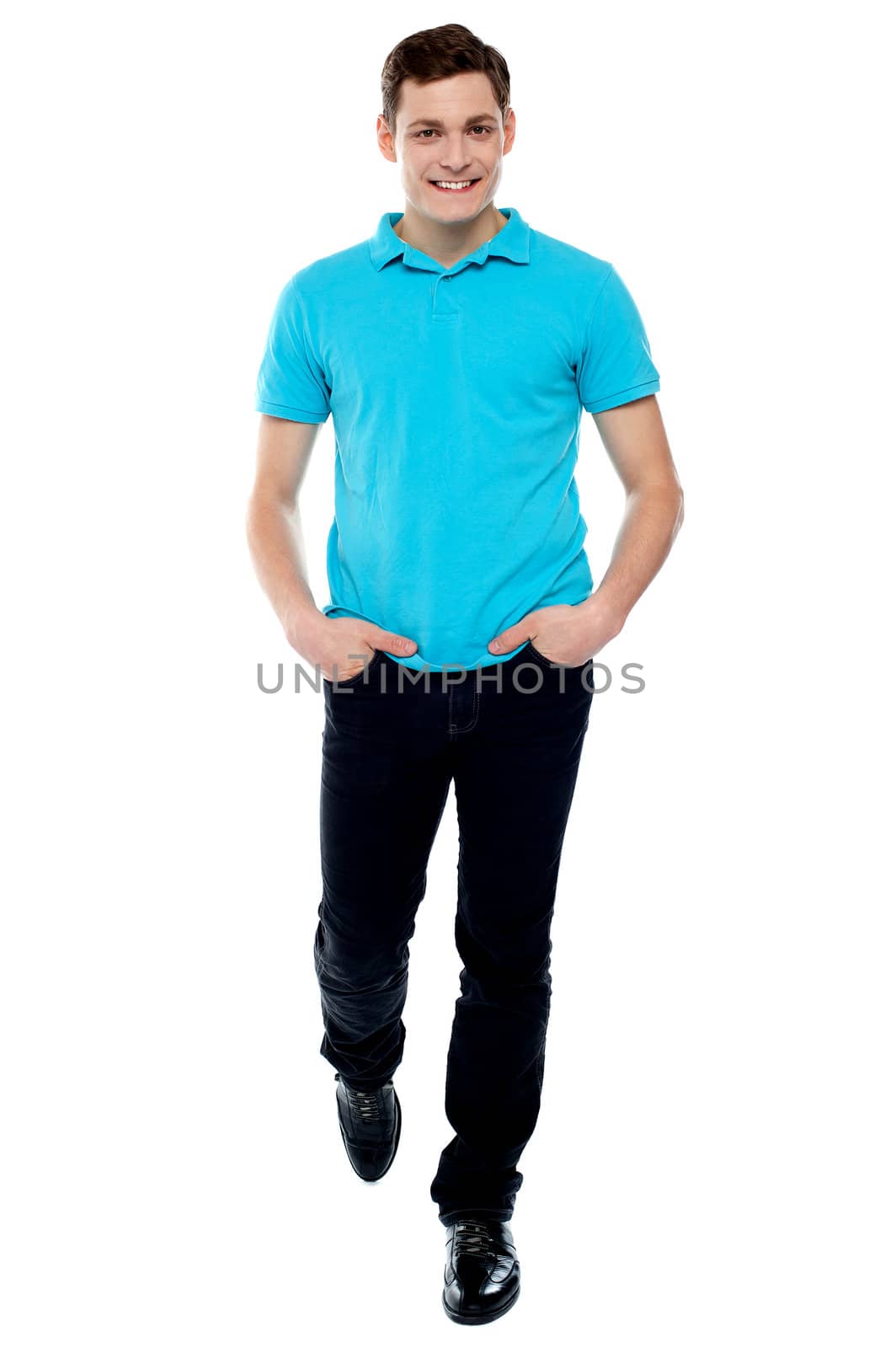 Handsome guy in walking pose. Studio shot over white background