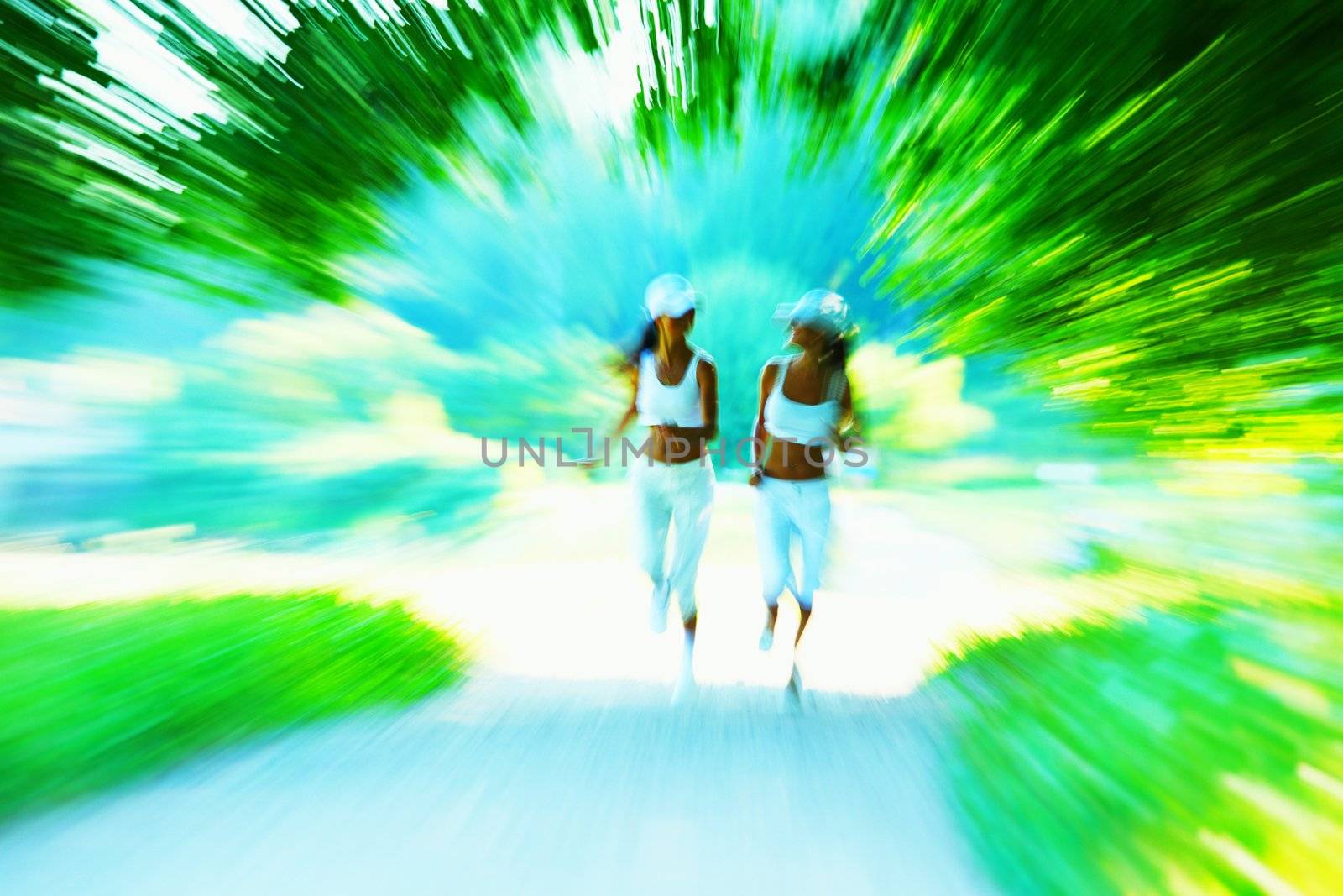 Beautiful young woman running in green park on sunny summer day
