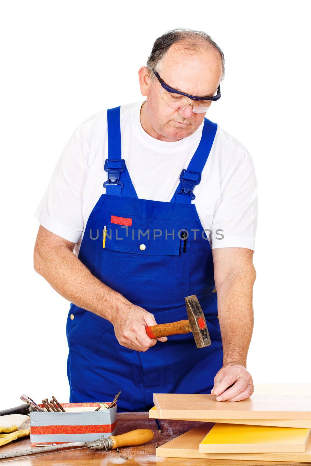 Middle age worker hammering nails in board, isolated on white background