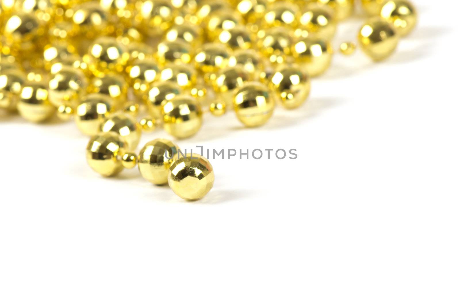 Background made of a brilliant celebratory beads of golden color over white