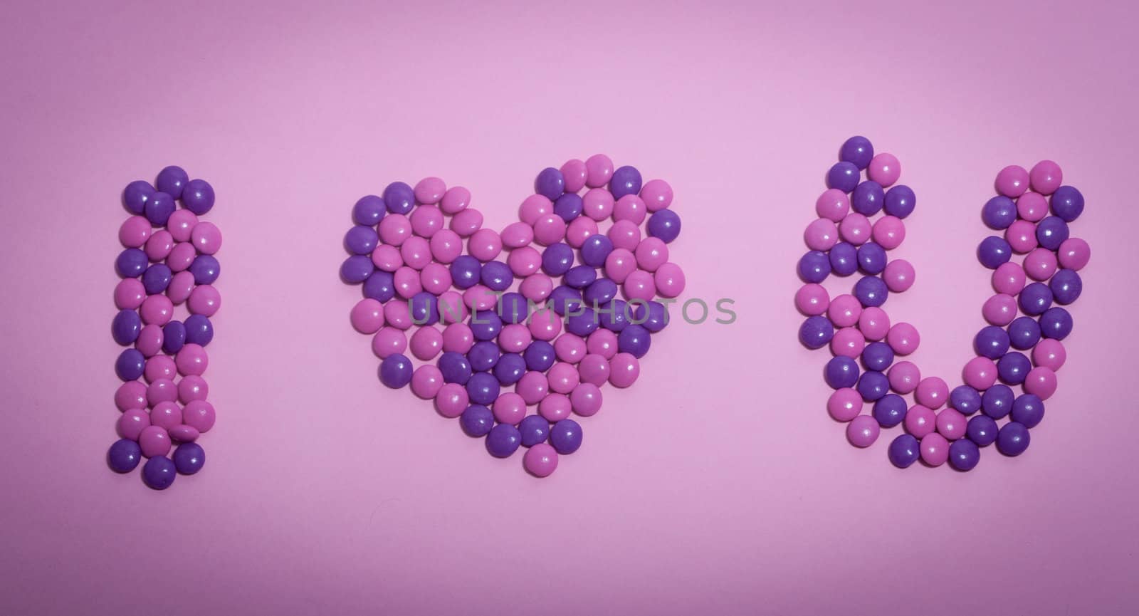 A bunch of chocolate buttons, in various colors such as pink, purple spelling "I love you".