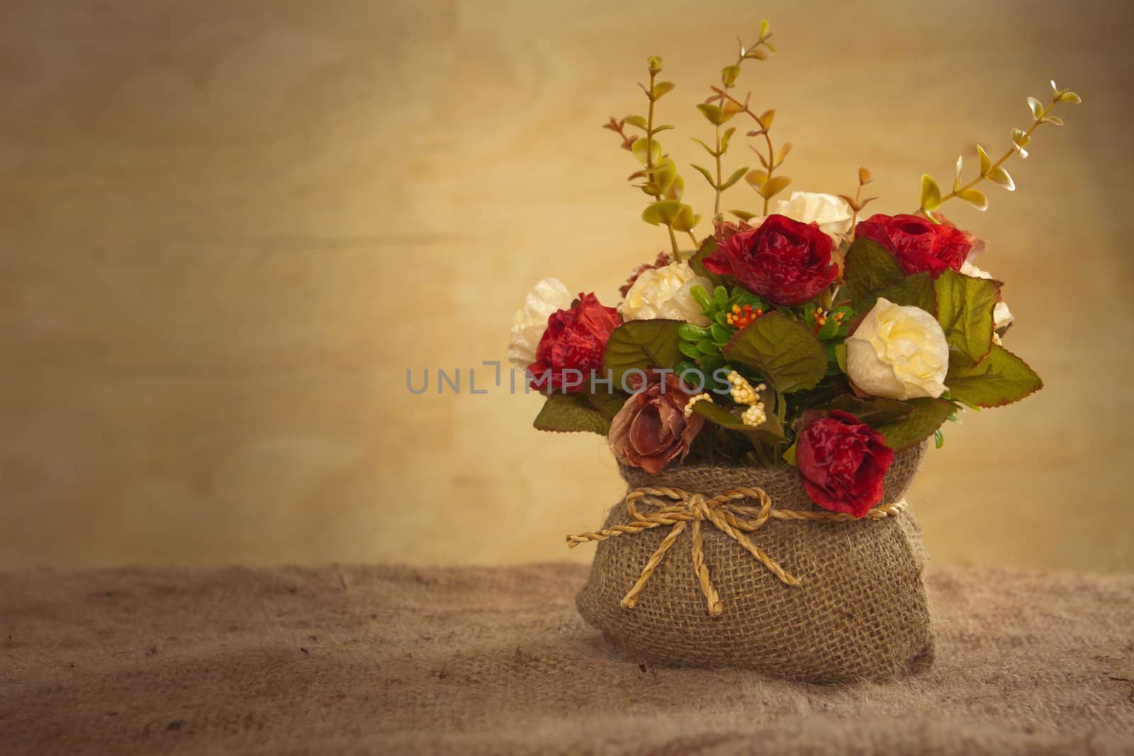 still life with rose flower on hessian background