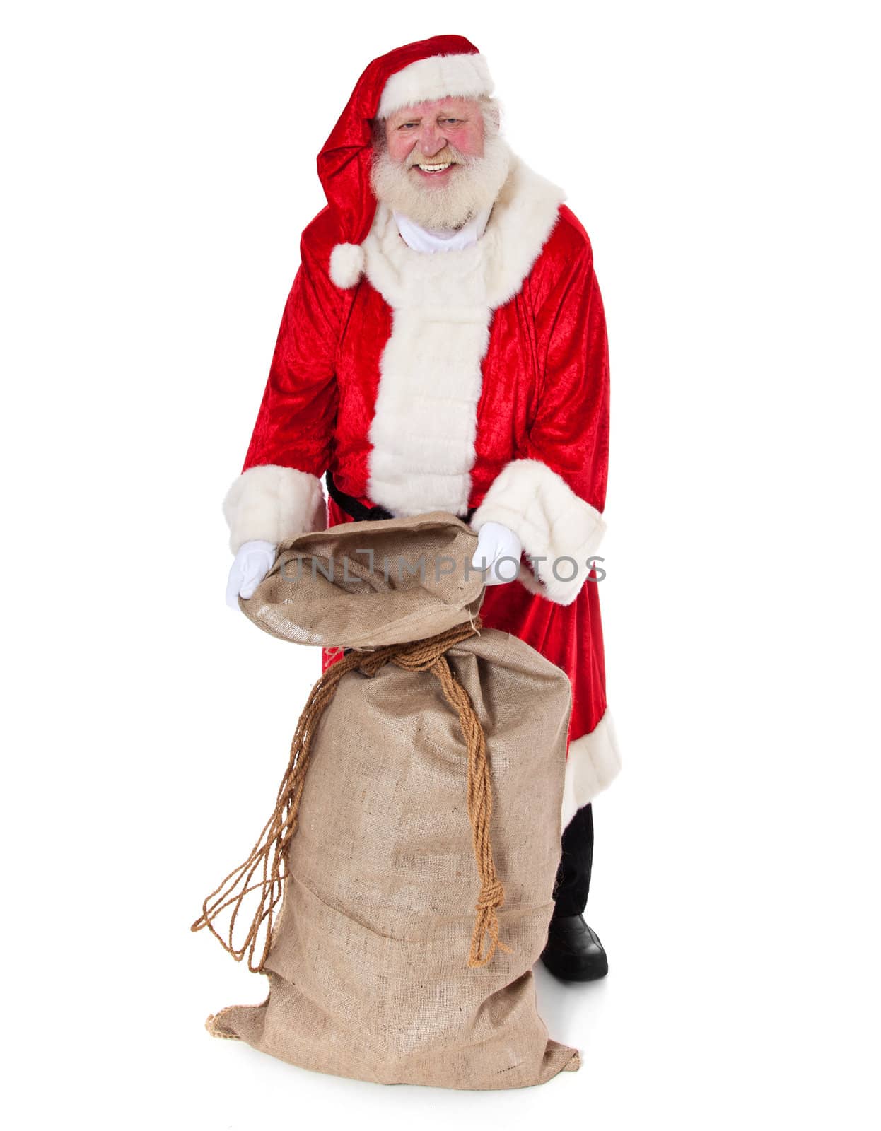 Santa Claus in authentic look opening his bag of presents. All on white background.