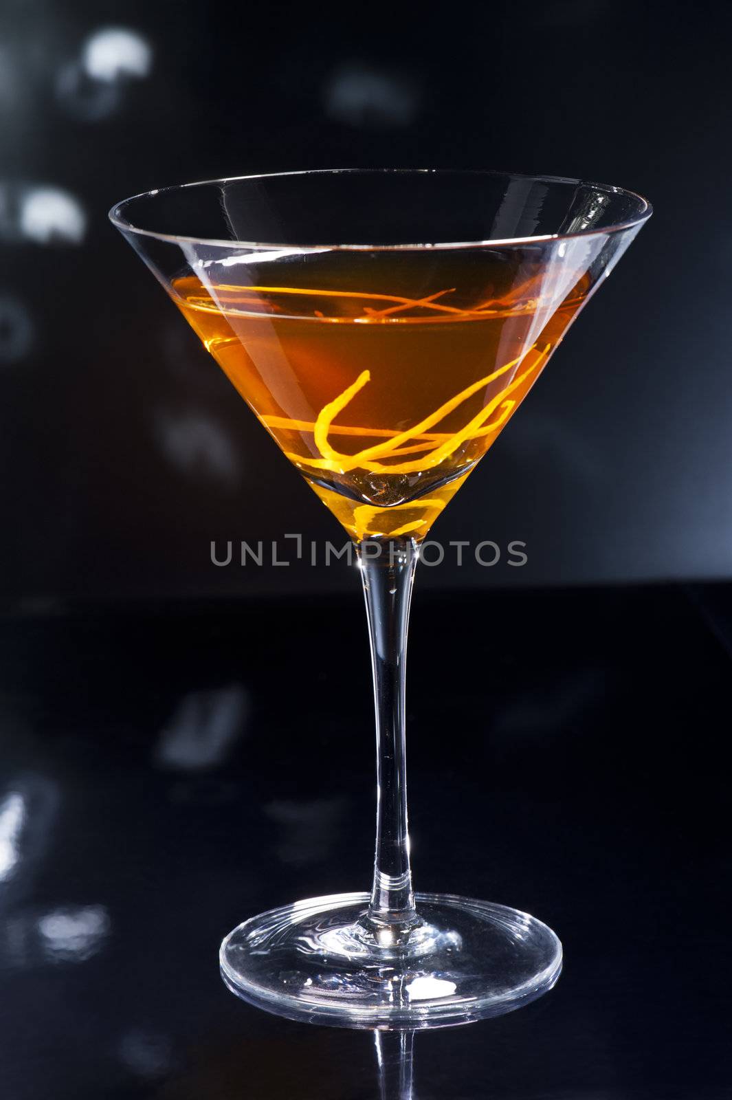 Manhattan cocktail over black and bright sparkles