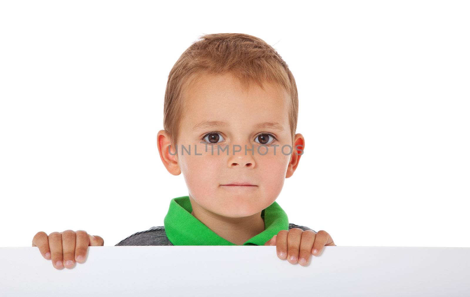 Cute little boy standing behind white wall. All isolated on white background.