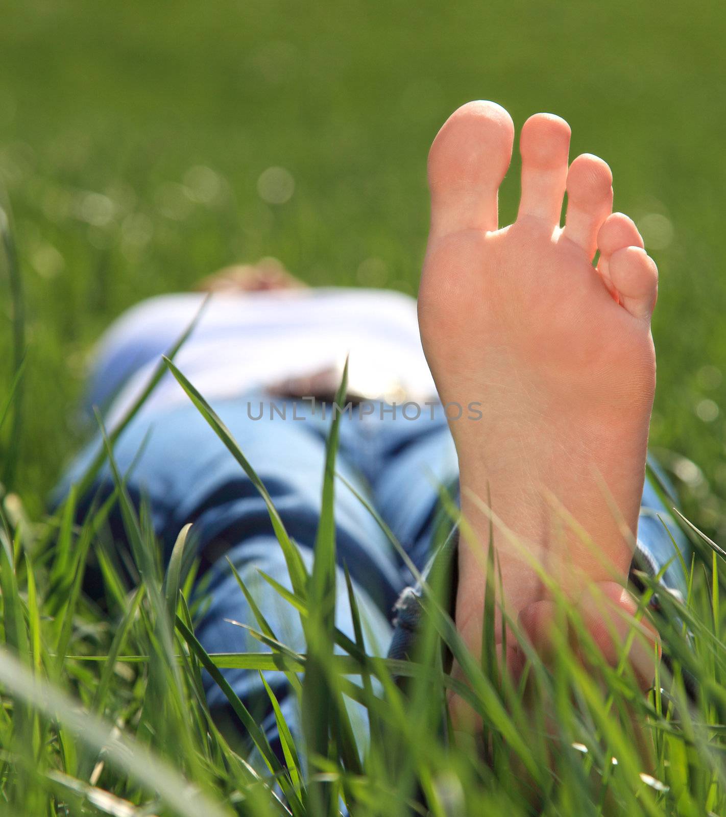 Female person resting outside on green meadow.