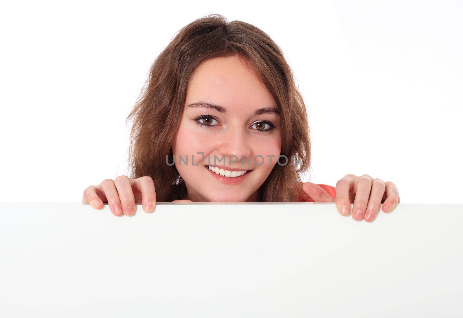 Attractive teenage girl behind white wall. All on white background.