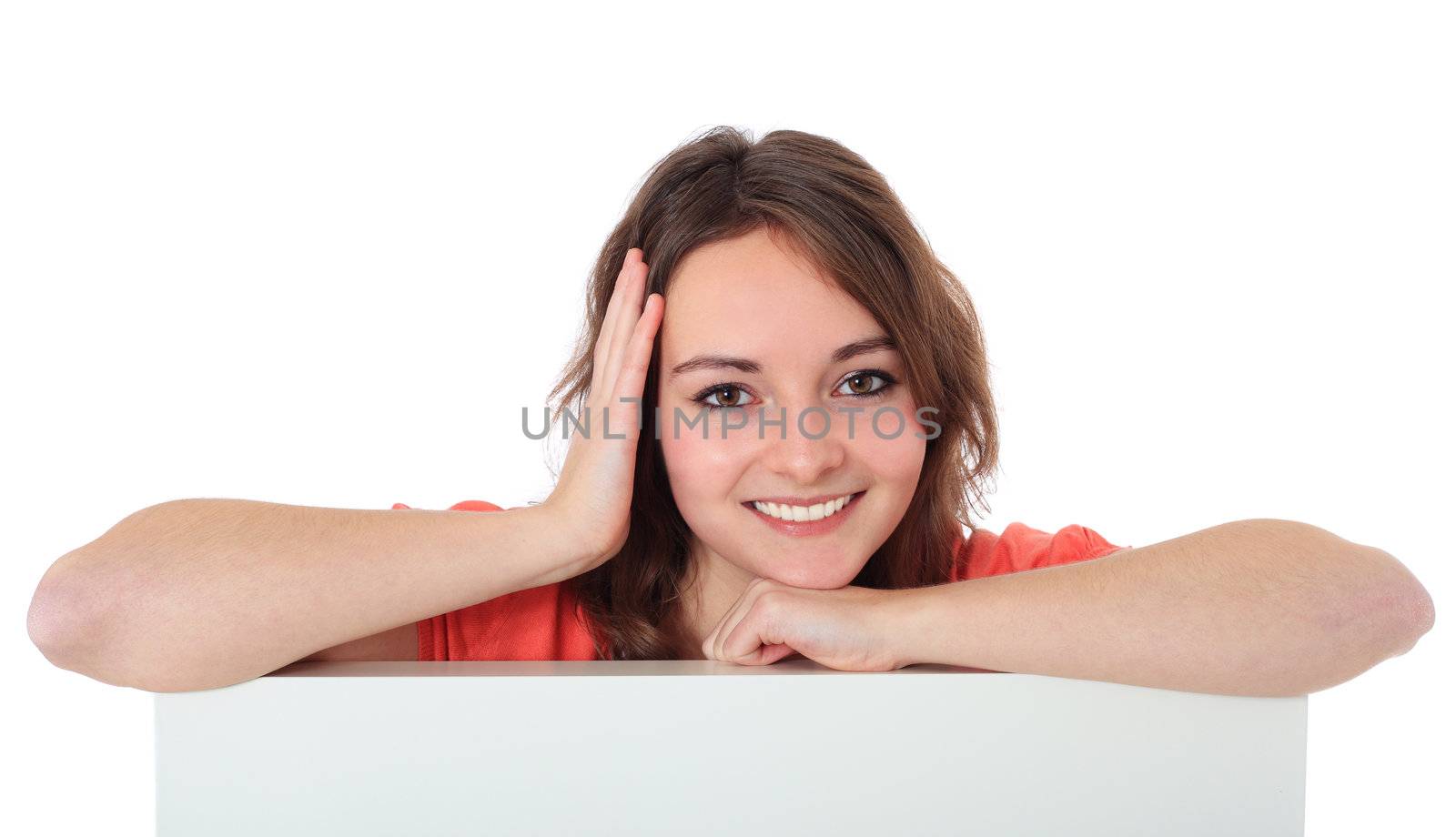 Attractive teenage girl behind white wall. All on white background.